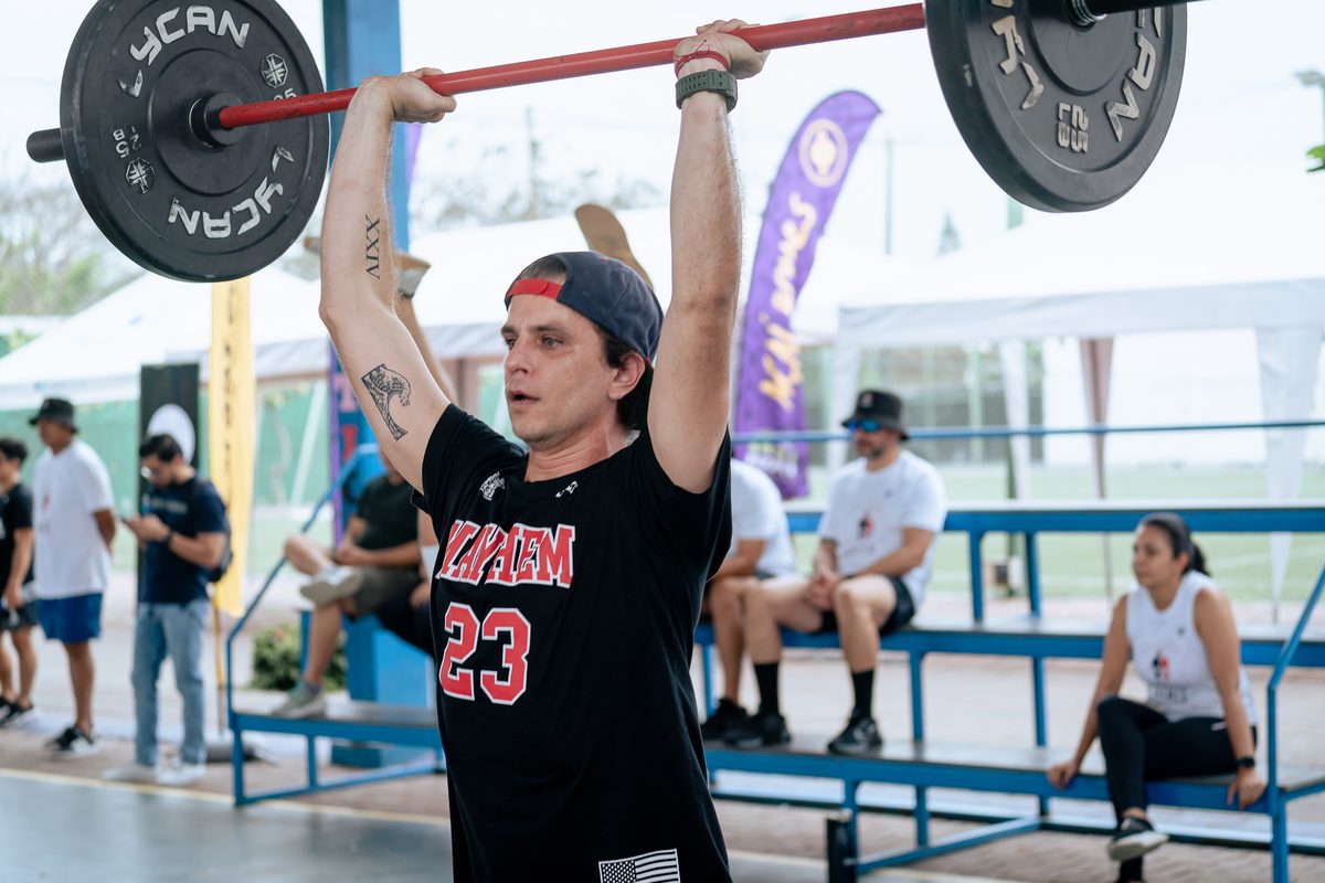 Atleta con barra sobre la cabeza